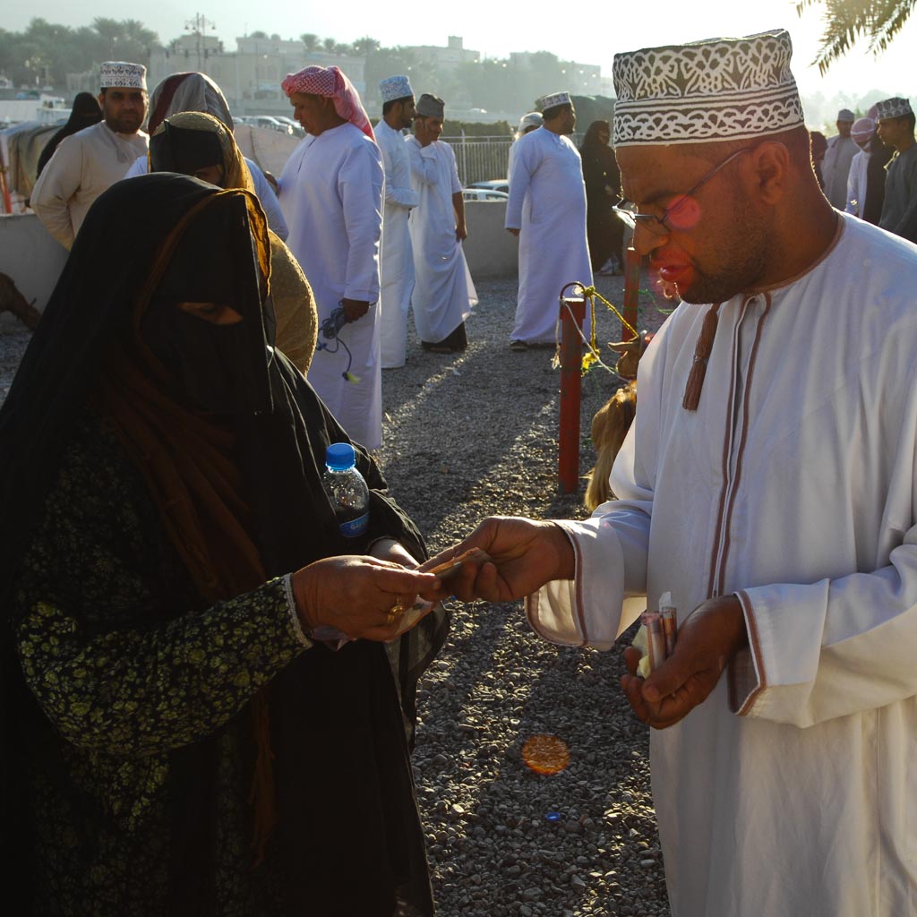 Cattle dealer pays woman, Nizwa, Oman